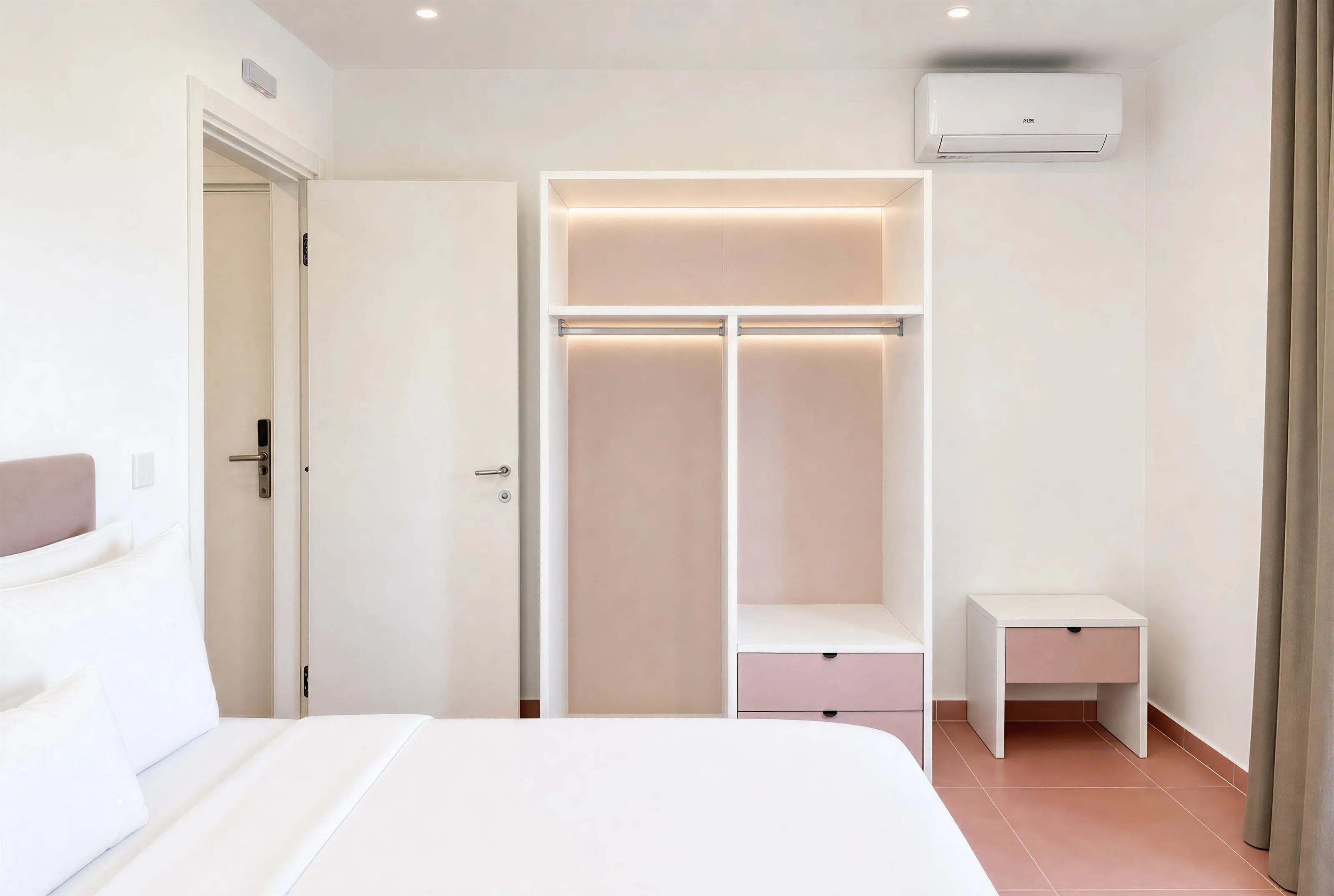 Bedroom with an open lit wardrobe, bedside table, air conditioning and the door