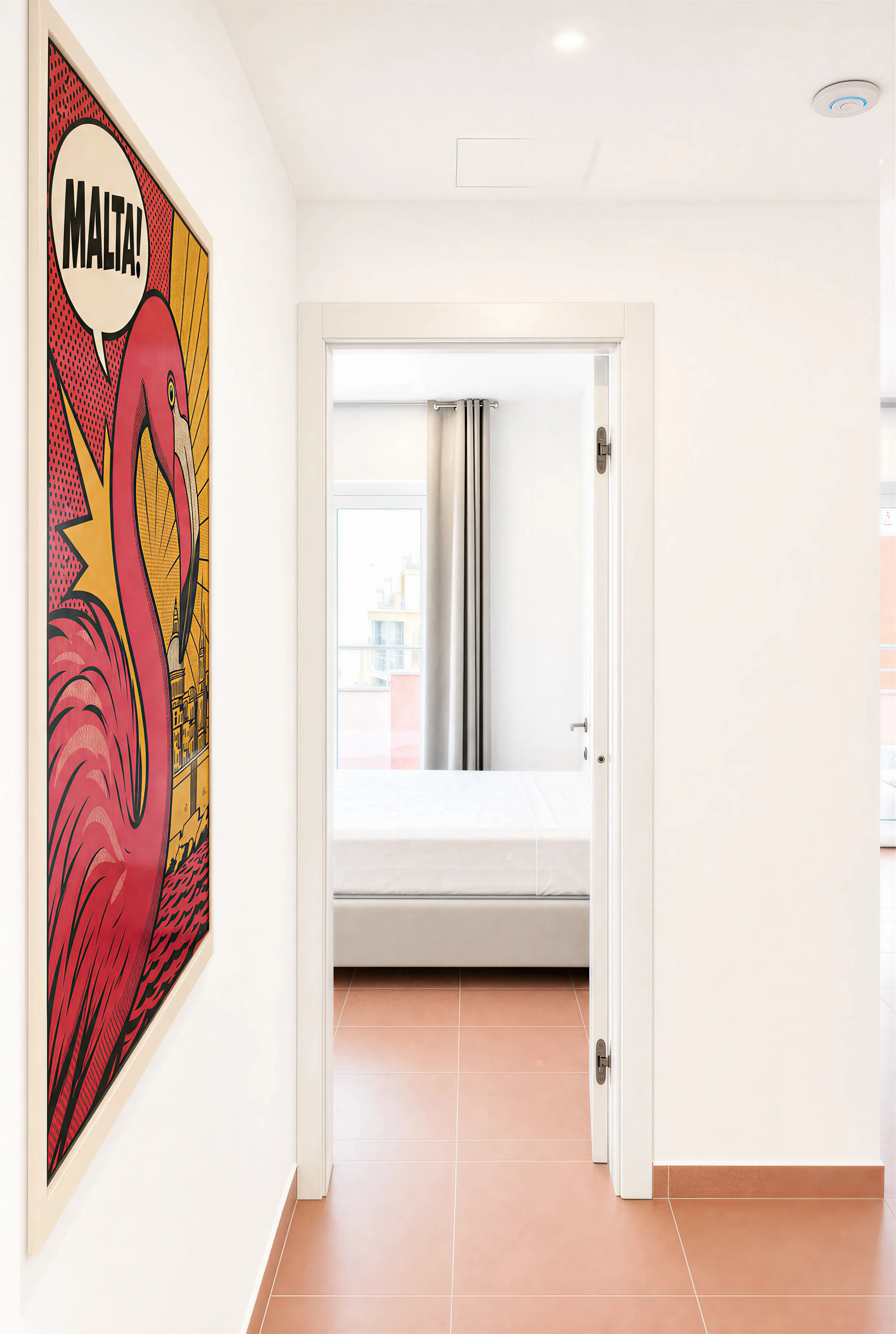 Hallway with a large 'MALTA!' flamingo pop-art print and a bedroom door