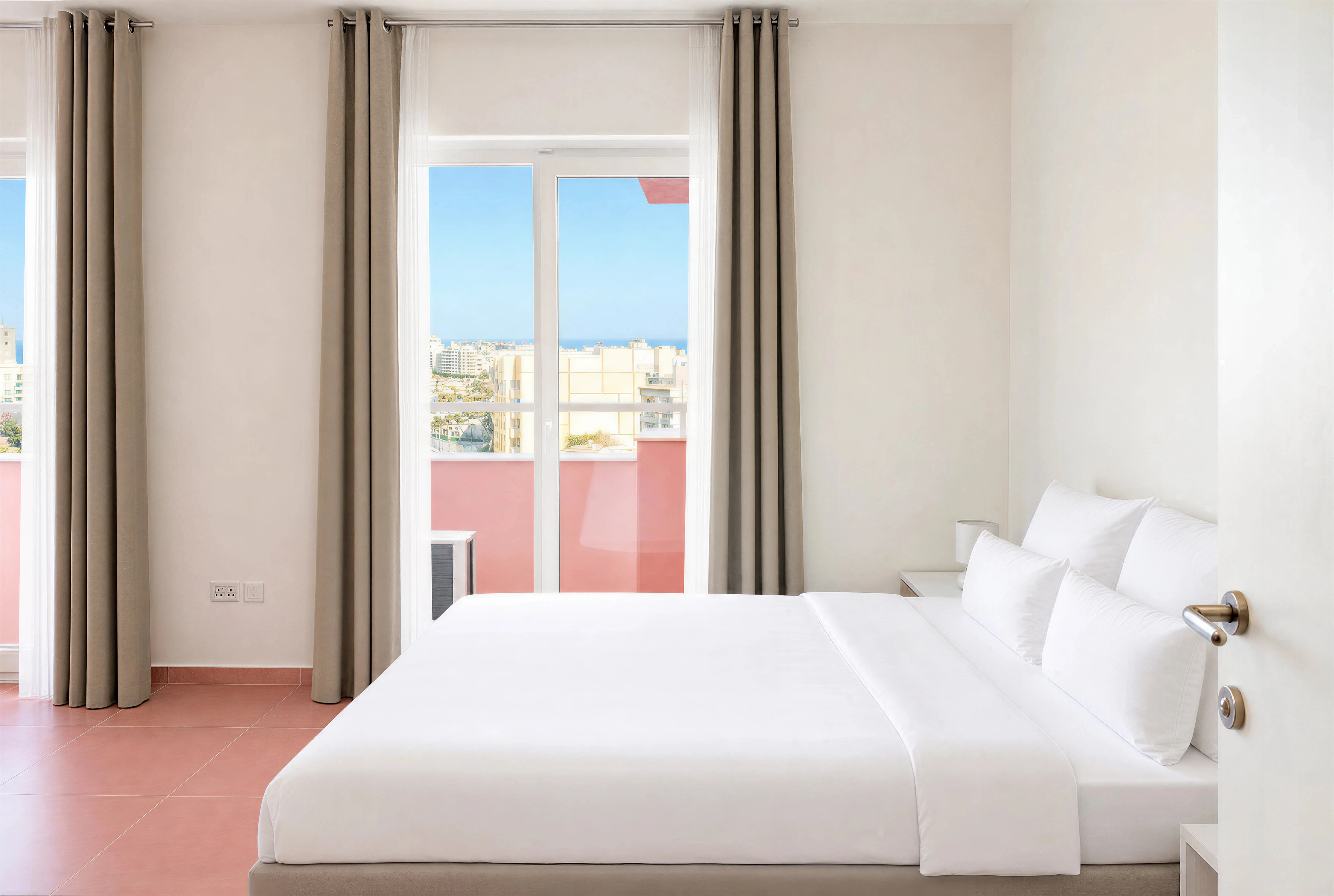 Master bedroom with double bed and balcony doors in a 2-bedroom Flamingo apartment