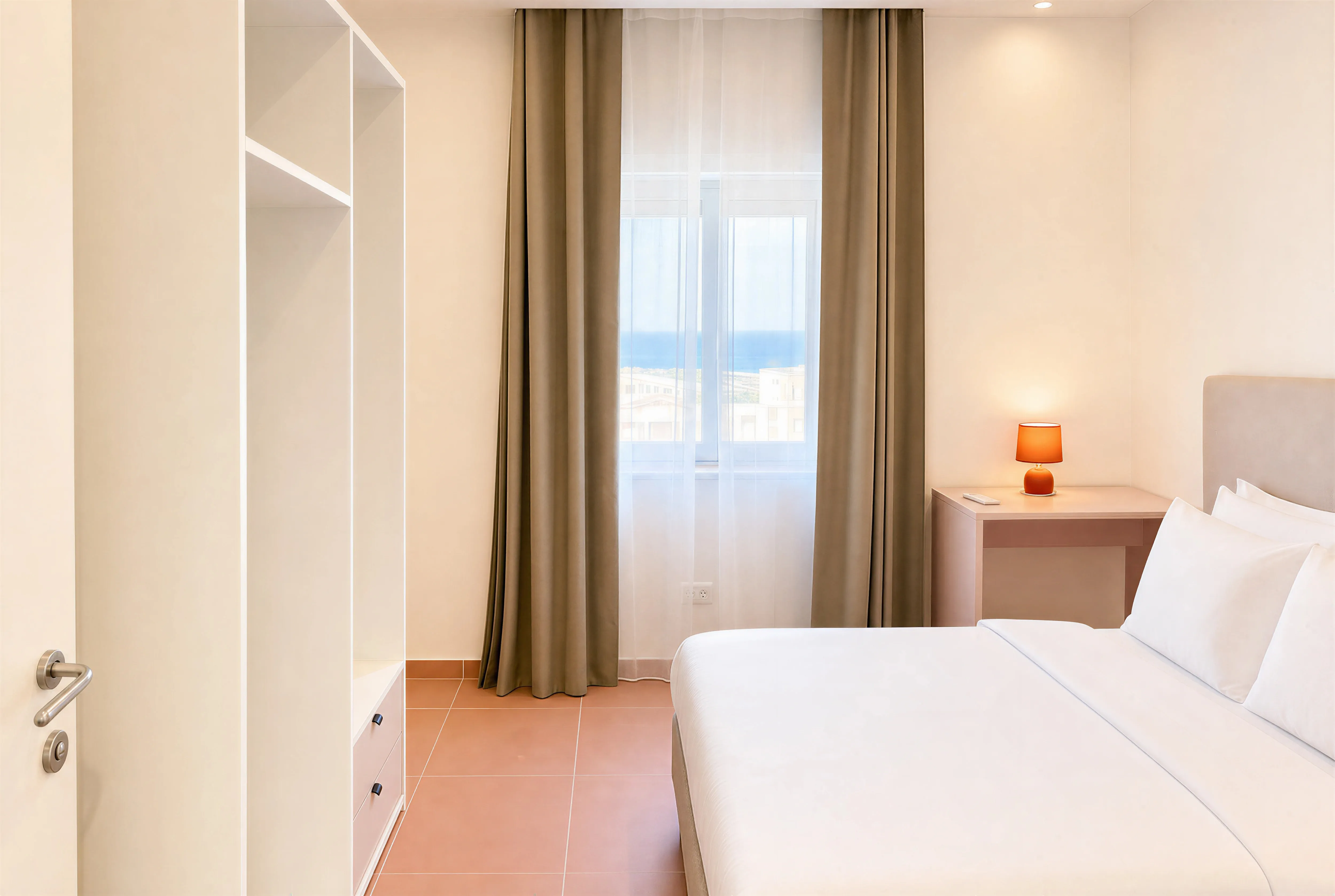 Bedroom with white bedding, cream headboard, bedside lamp and open wardrobe