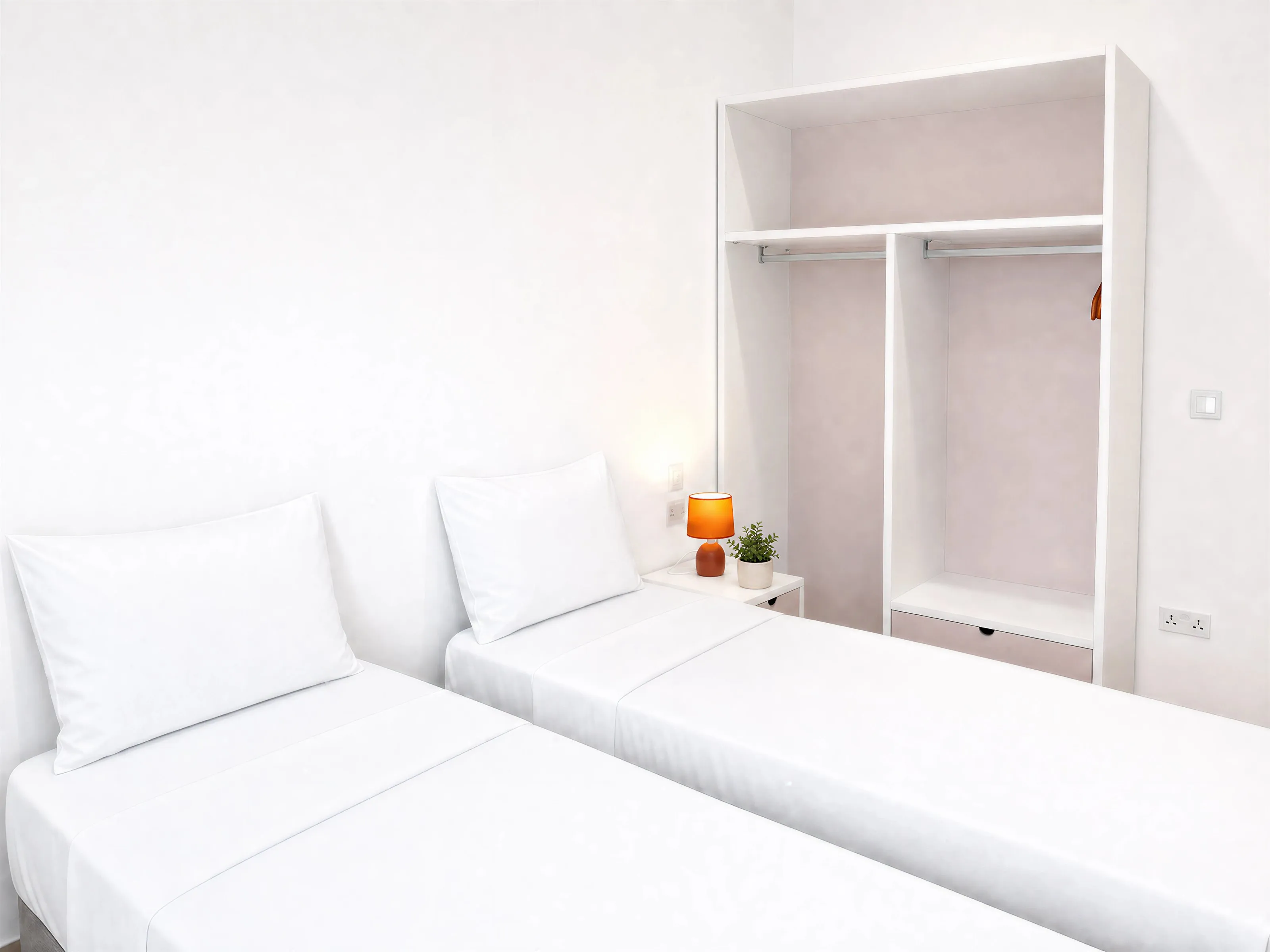 Two single beds with white linen, a bedside lamp and an open wardrobe